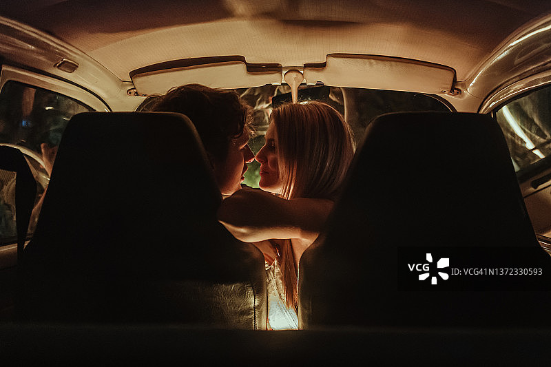 年轻情侣在车内约会亲吻图片素材