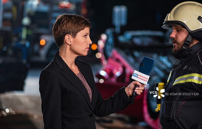 女新闻记者在车祸现场采访消防员图片素材