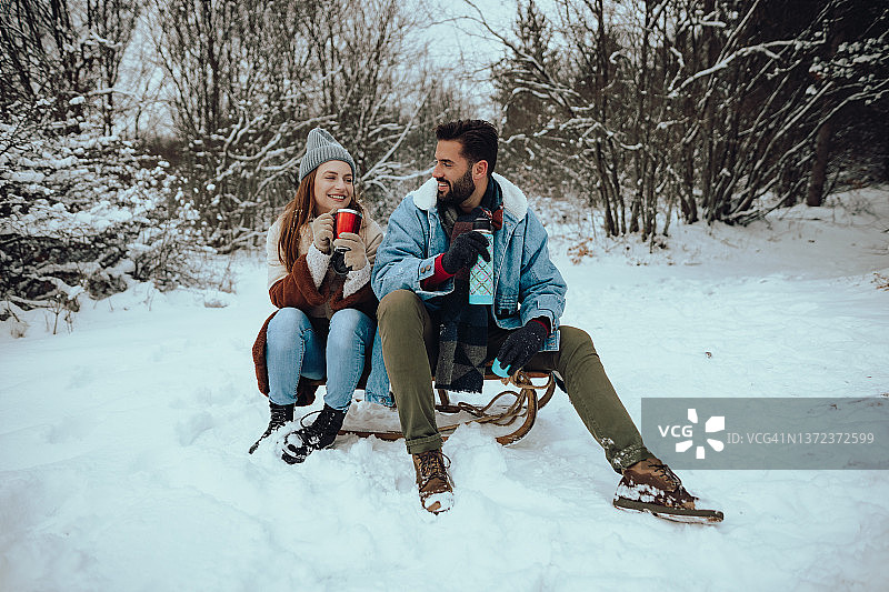 在雪地里享受冬日乐趣的幸福情侣图片素材