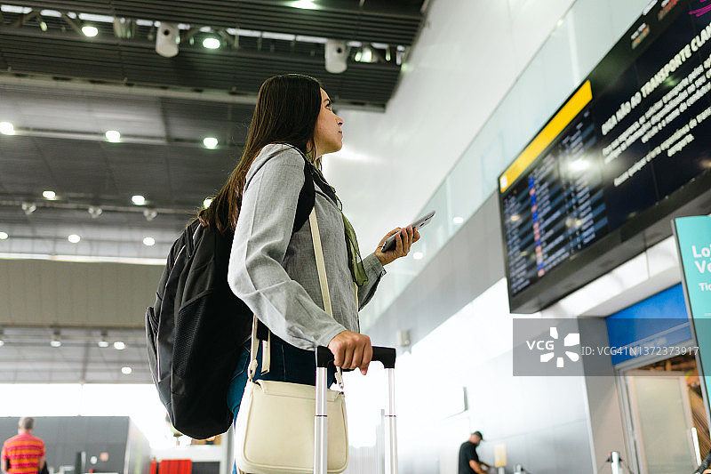 商务旅客查看航班信息板图片素材