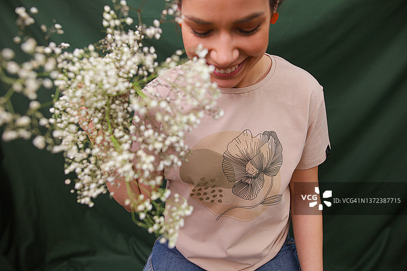 在工作室拍摄期间宣传其新服装系列的年轻白人女性图片素材