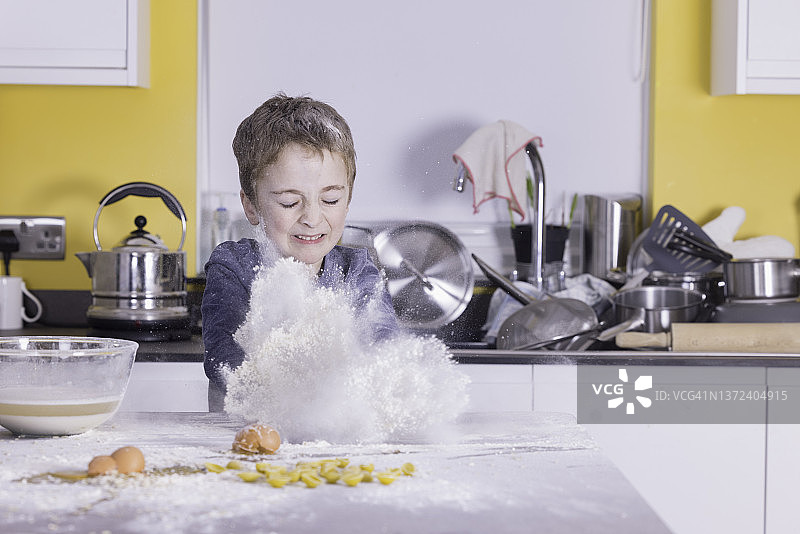 在厨房里制造混乱的小男孩图片素材