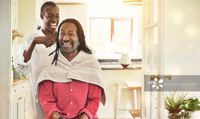 老妇在家中厨房为丈夫打理脏辫图片素材