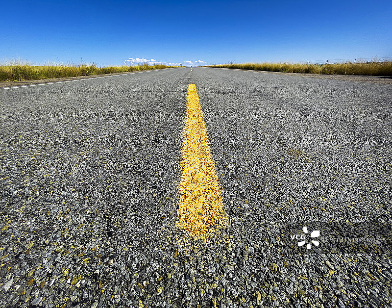 特写：沥青公路上的黄色分隔线图片素材