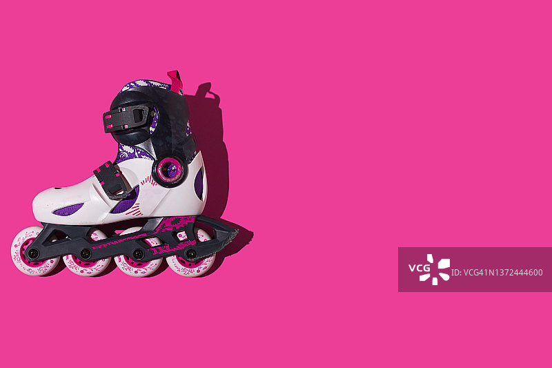 粉色背景左侧轮滑鞋黑白紫色轮子图片素材
