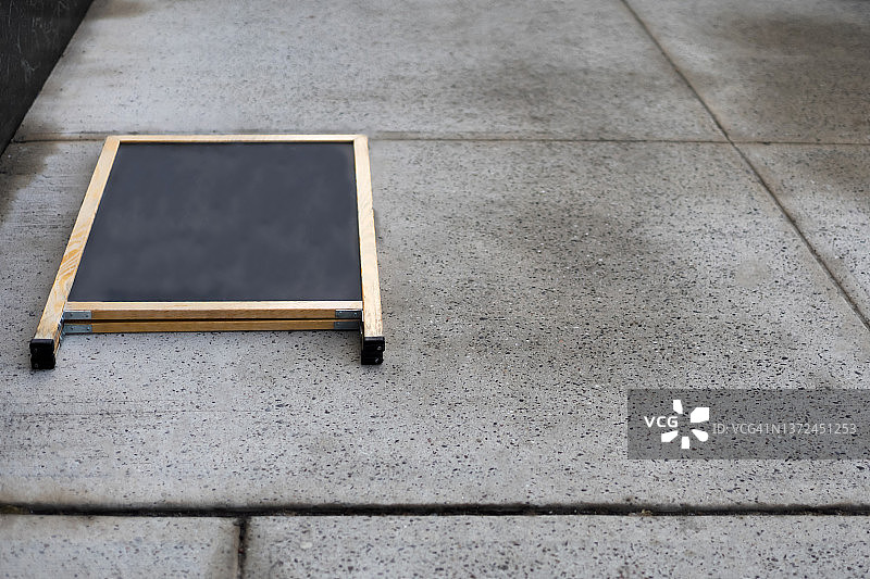 强风吹倒零售店人行道黑板图片素材