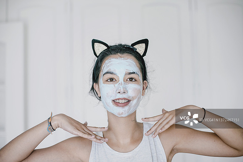 戴着护肤面膜的拉丁裔年轻女子肖像图片素材