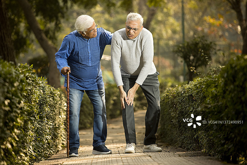 老年男人在公园里膝盖疼痛图片素材