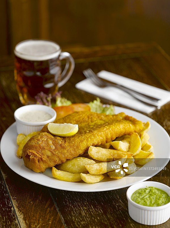 酒吧里的炸鱼薯条配酱汁和啤酒图片素材