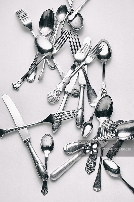 白色餐桌上的各种叉子、刀子和勺子图片素材