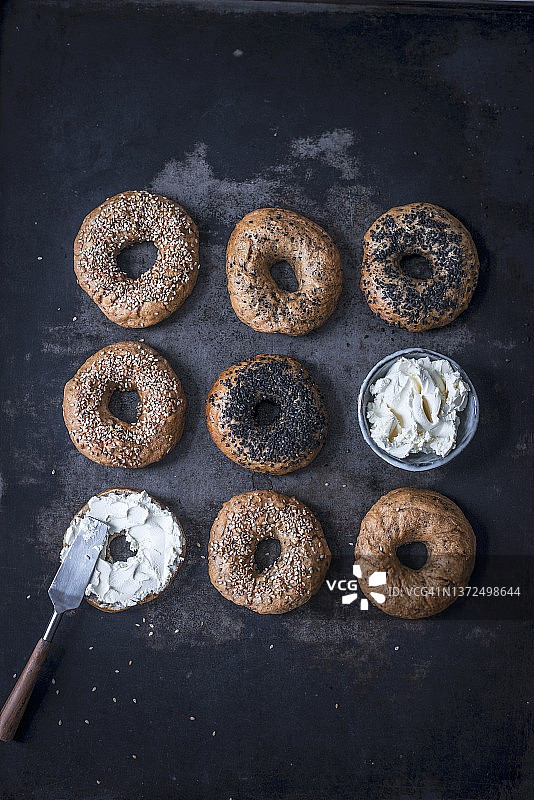 带有白色和黑色芝麻以及新鲜奶酪的斯佩尔特面包圈图片素材