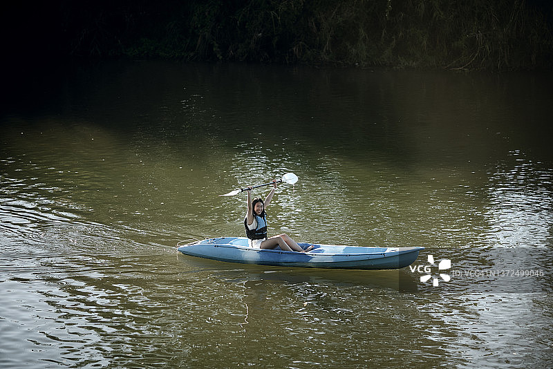 亚洲青年在河中享受皮划艇运动，积极的周末活动图片素材