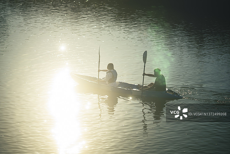 亚洲家庭的兄妹在河上划皮划艇图片素材