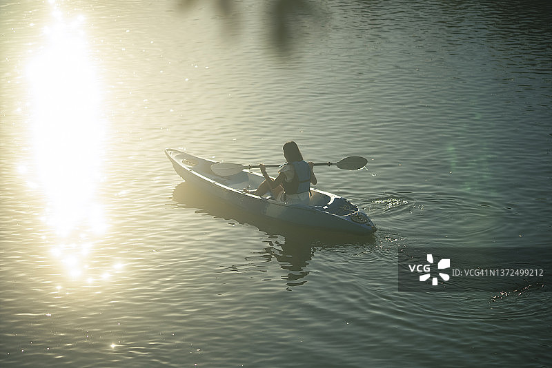 阳光下的日落亚洲青年皮划艇活动图片素材