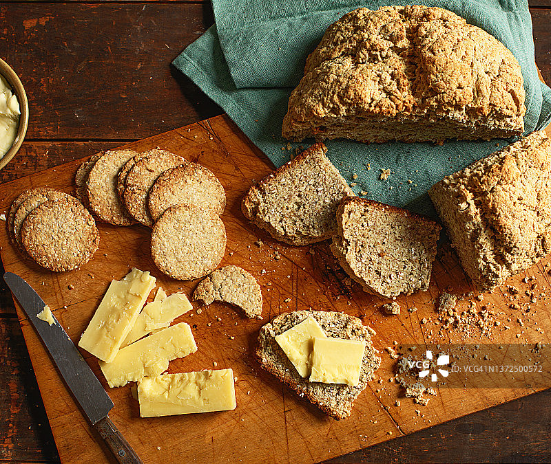 木制砧板上的苏打面包、苏打饼干、黄油和奶酪图片素材
