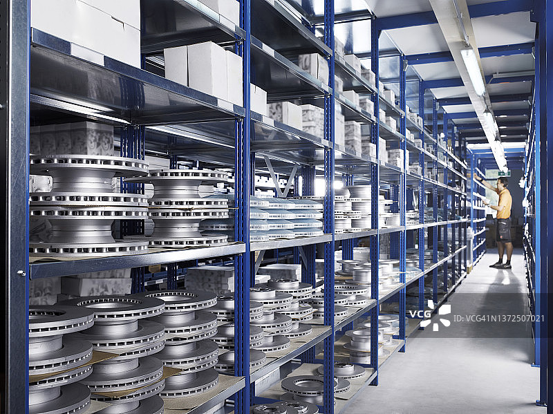 维修店小巷里，技术员在备件架之间图片素材