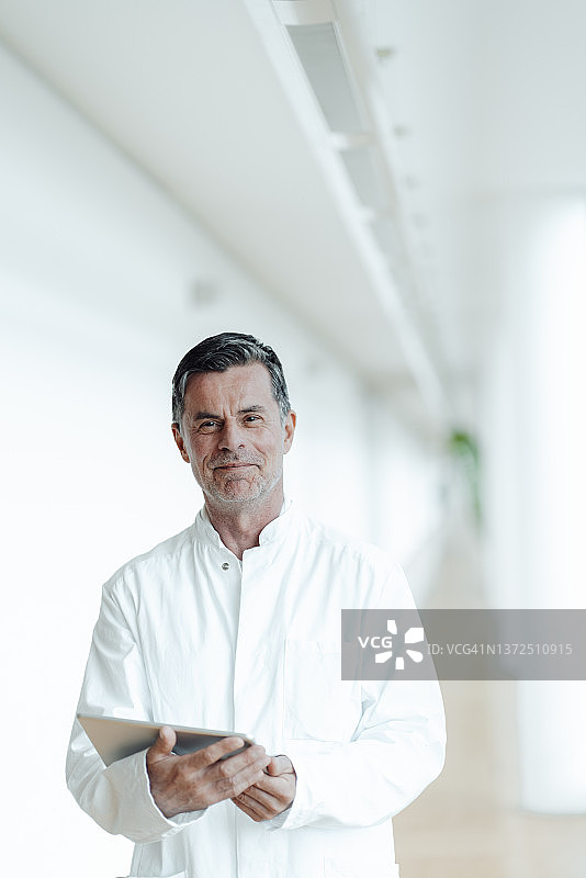 面带微笑的科学家在医疗诊所手持平板电脑图片素材