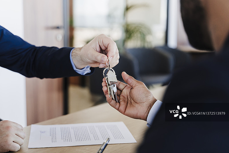 房地产经纪人在办公室向买家交付房屋钥匙图片素材