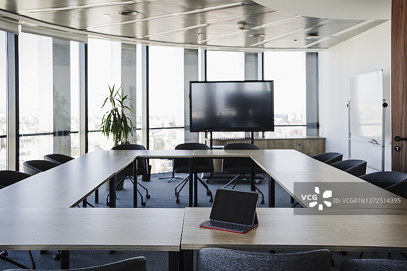 办公室里桌子上放着笔记本电脑的空旷会议室图片素材