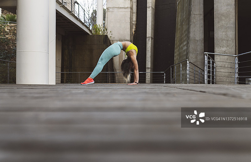 在公园人行道上向后弯腰的年轻运动员图片素材