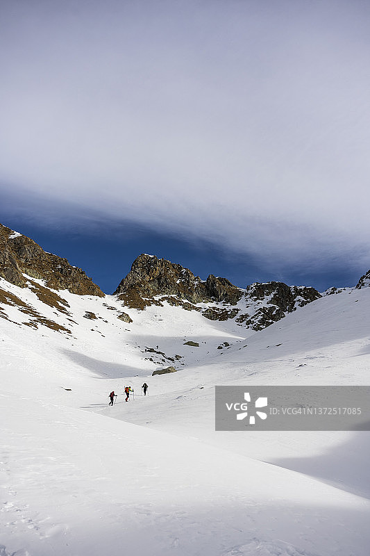 在意大利瓦尔泰利纳的奥罗比克阿尔卑斯山上，滑雪登山者在雪地里走向山峰图片素材