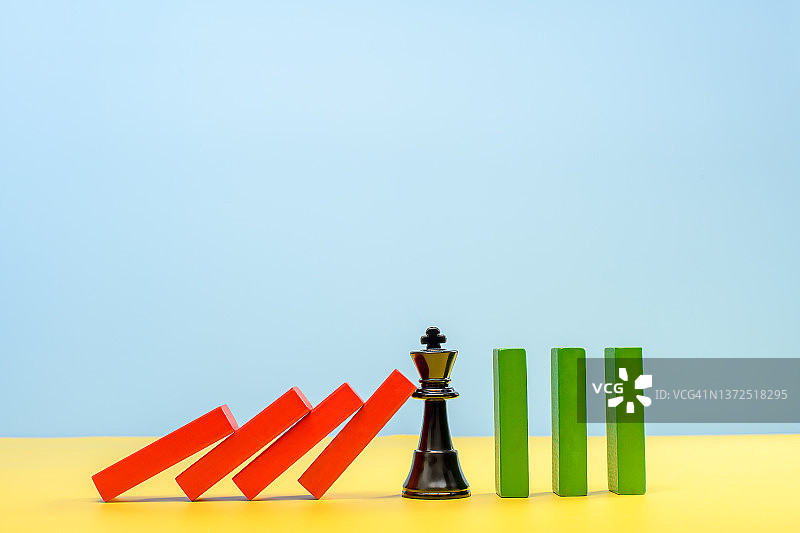 国王棋子阻止多米诺骨牌效应，商业解决方案概念图片素材