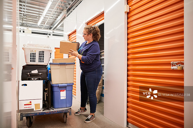 女人在自助仓储单元搬运物品图片素材