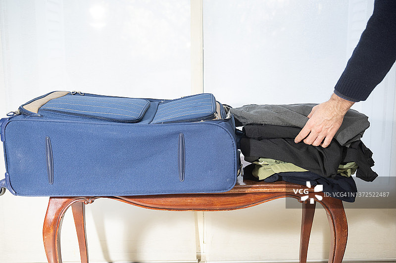 男人在家收拾行李箱准备去度假图片素材