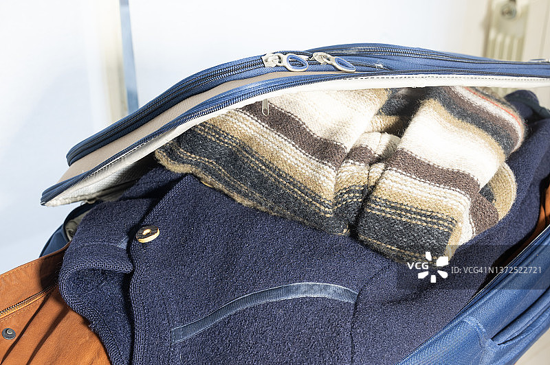 装满无法关闭的衣服的行李箱图片素材