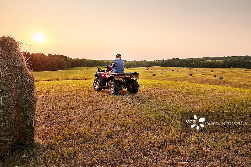 年长的男农民在农田的沙滩车上图片素材
