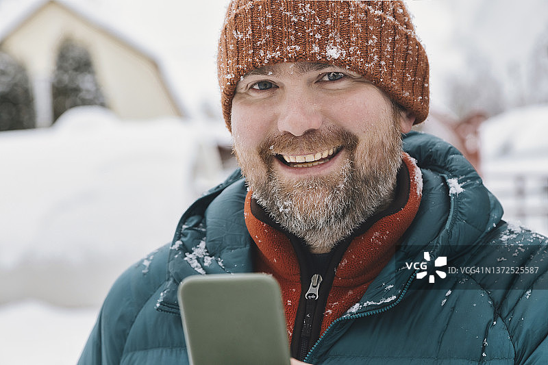 冬天里使用手机的快乐男人图片素材