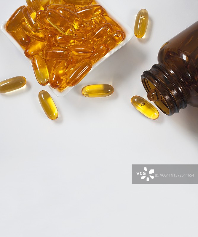 盘子和瓶子里的鱼油胶囊图片素材