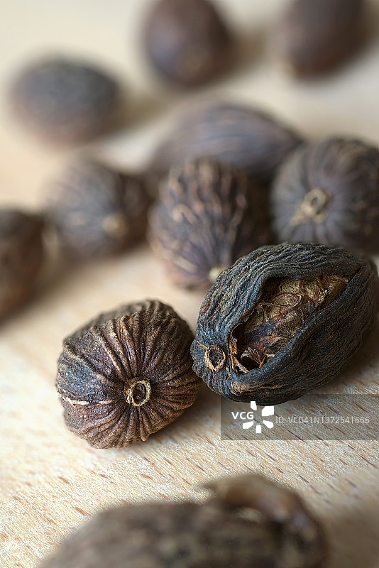 木质表面上的干制黑色小豆蔻图片素材