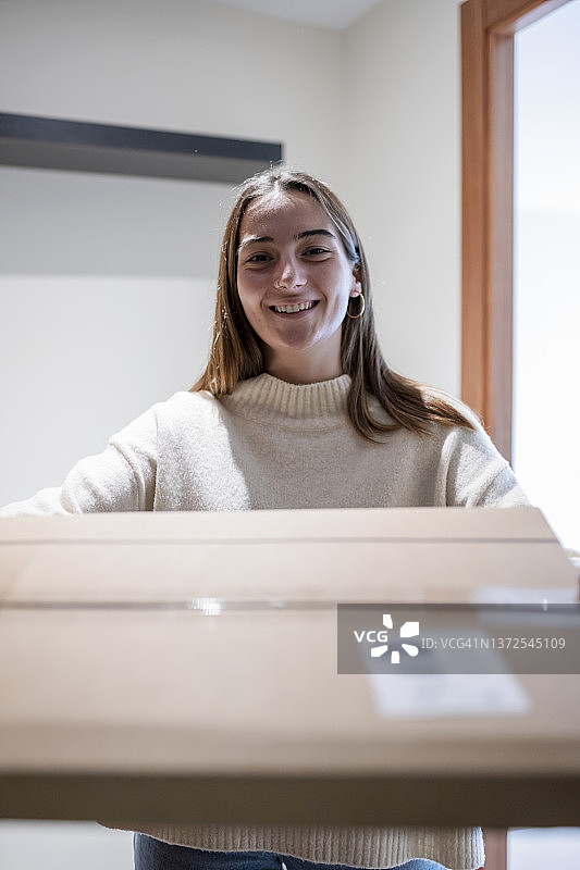 年轻女人在室内从快递员处接收包裹图片素材