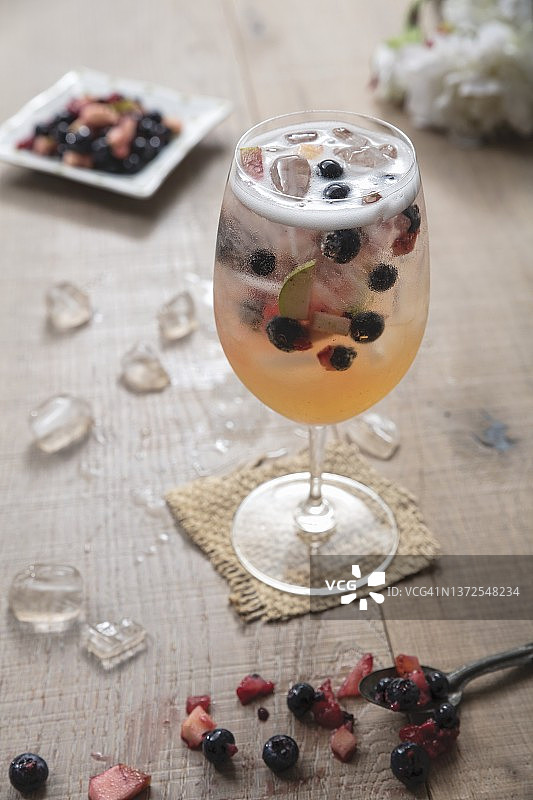 大酒杯中盛满覆盆子的白色桑格利亚汽酒和冰块图片素材