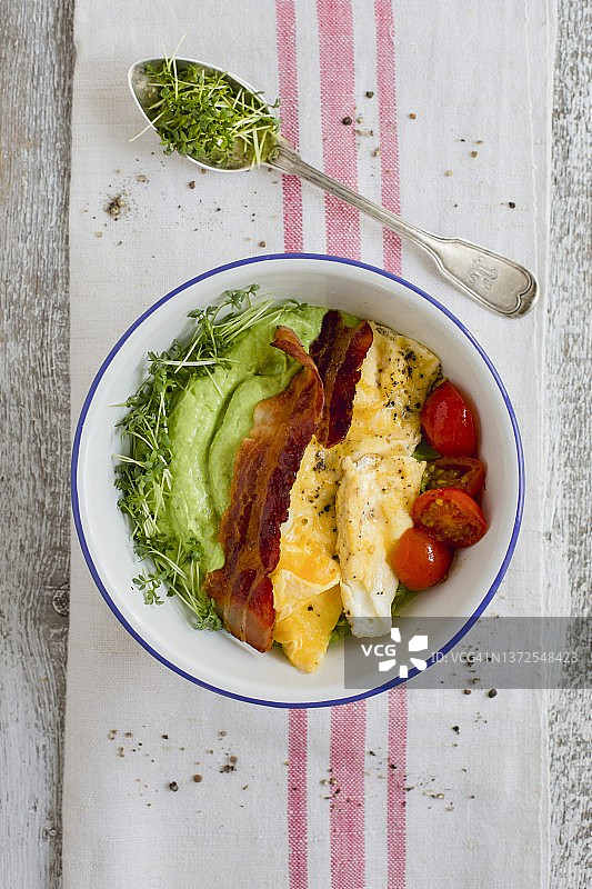 牛油果黄瓜奶油、炒鸡蛋、培根和番茄早餐碗图片素材