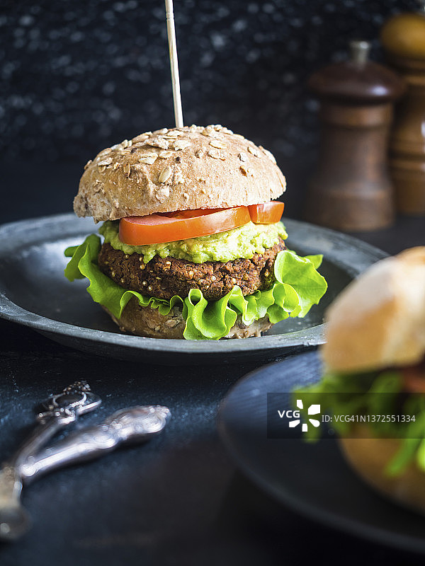 健康纯素藜麦红豆汉堡三明治配牛油果酱、生菜和番茄图片素材