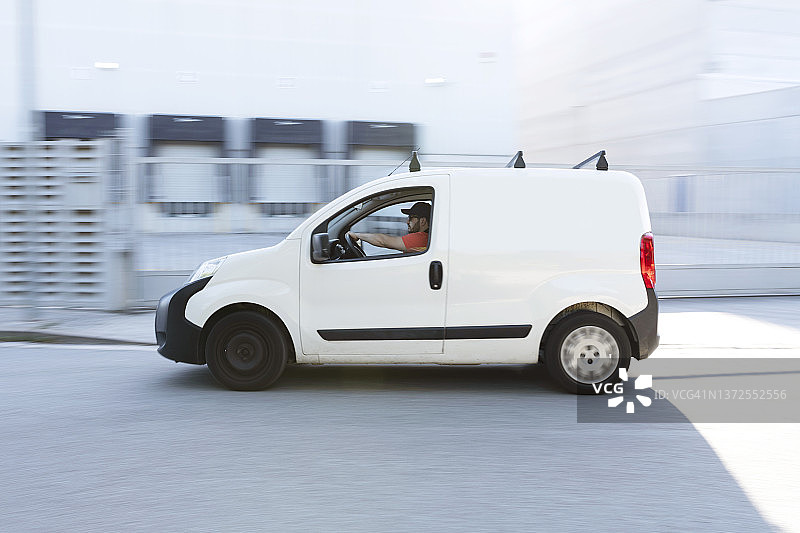 快速送货车行驶在城市街道上图片素材