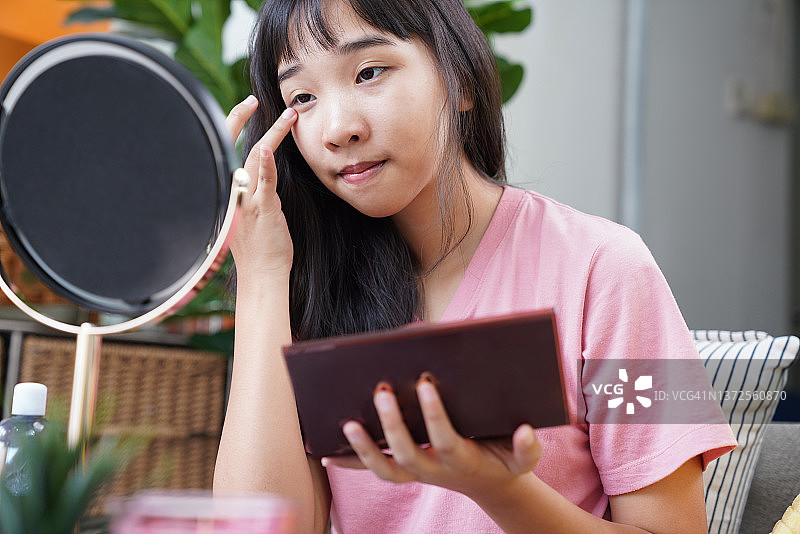 年轻女子化妆，在眼睛上涂抹眼影图片素材