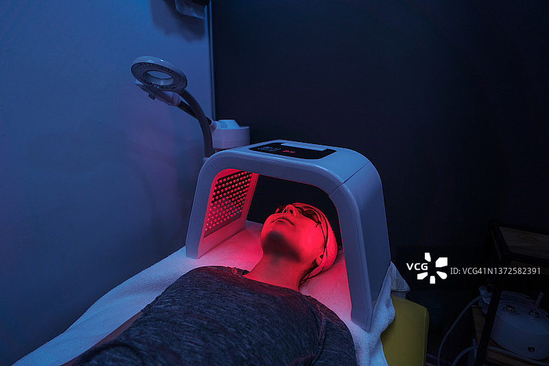 年轻女子面部红光疗法图片素材