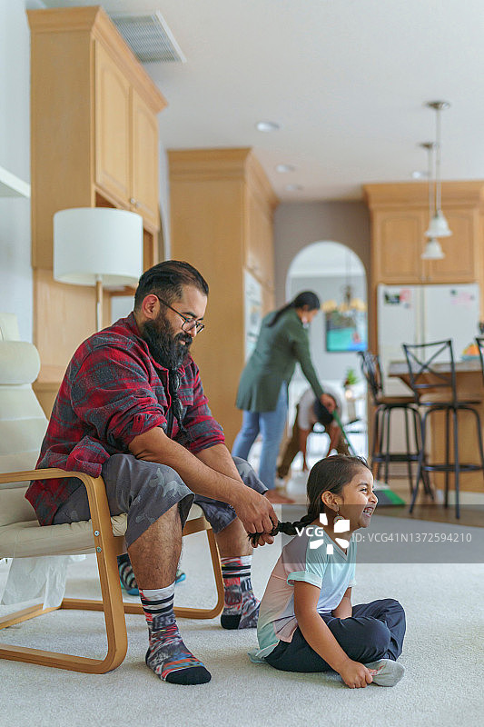 美洲原住民父亲为女儿编辫子图片素材