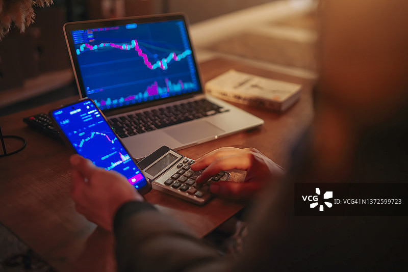 金融数据概念：在电脑显示器上分析加密货币和金融数据，配合智能手机使用图片素材