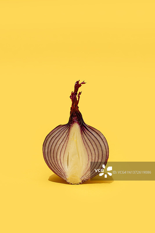黄色背景上的半个红洋葱图片素材