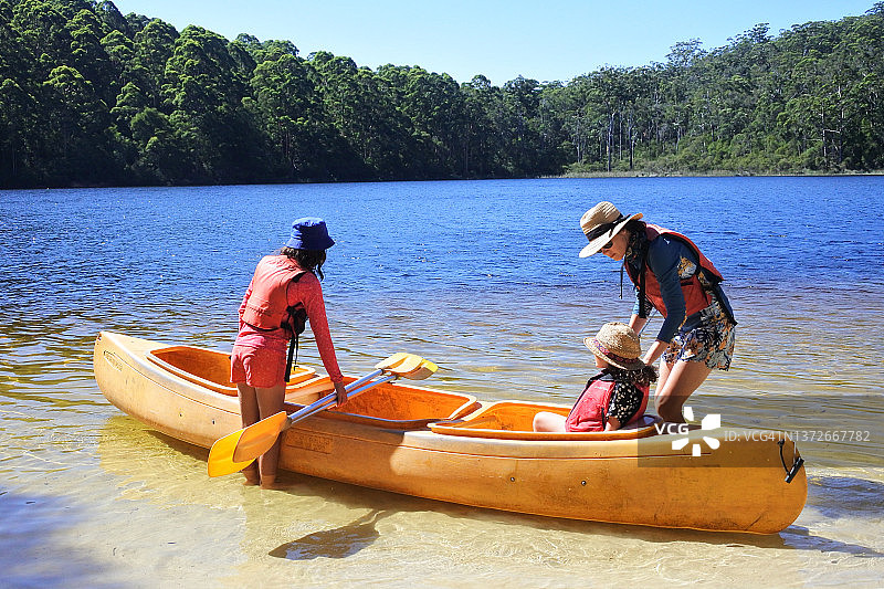 母亲和女儿们准备在湖上一起划独木舟图片素材