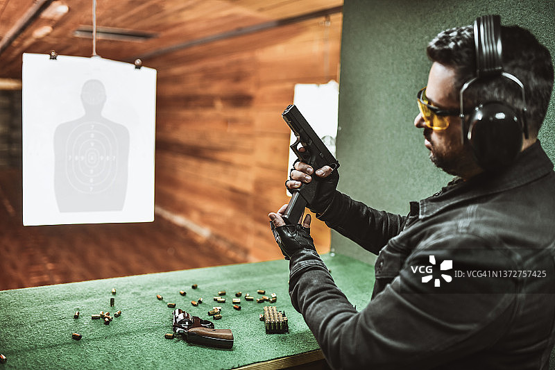 微笑的男人展示如何正确装枪图片素材