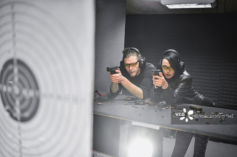 男枪械教官在靶场教授女学员瞄准技巧图片素材