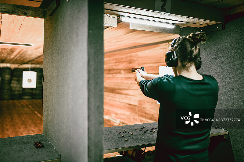 在靶场进行远程手枪训练的长发男人图片素材