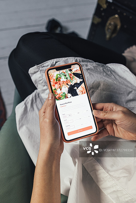 一位女士在隔离期间使用智能手机在线订餐图片素材