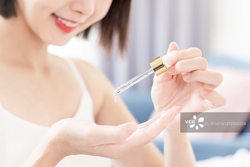 女人将润肤霜滴在手上图片素材