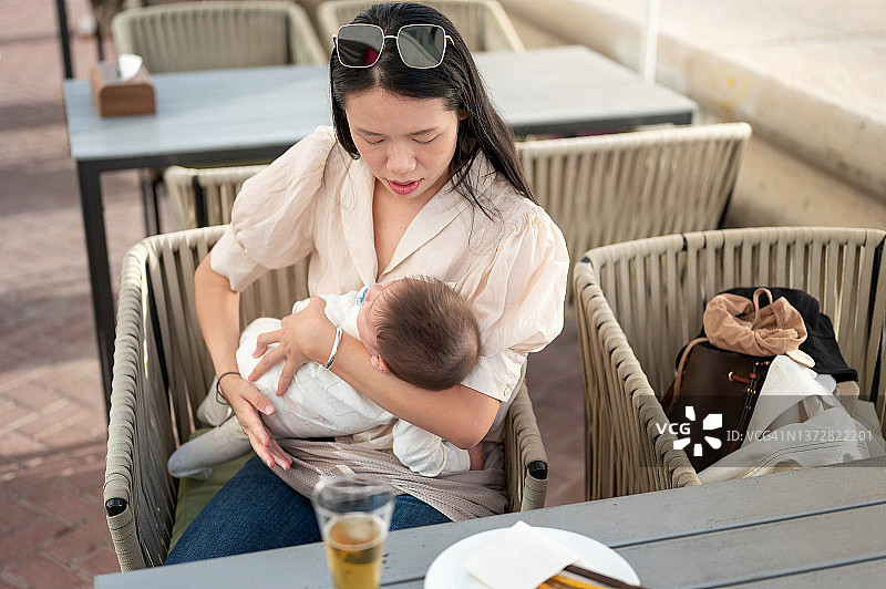 年轻的母亲和她的宝宝在餐厅共度美好时光图片素材